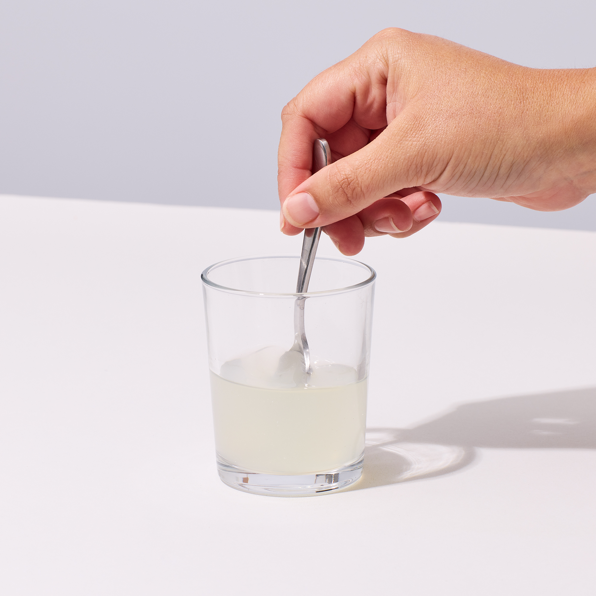 image of person mixing Isotonix Magnesium with 2 oz of water in a glass