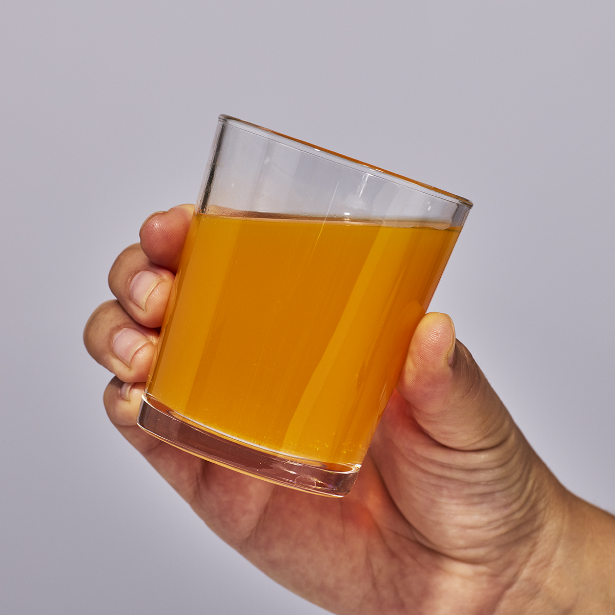 image of person holding a glass containing one serving of Isotonix Prenatal Activated multivitamin.