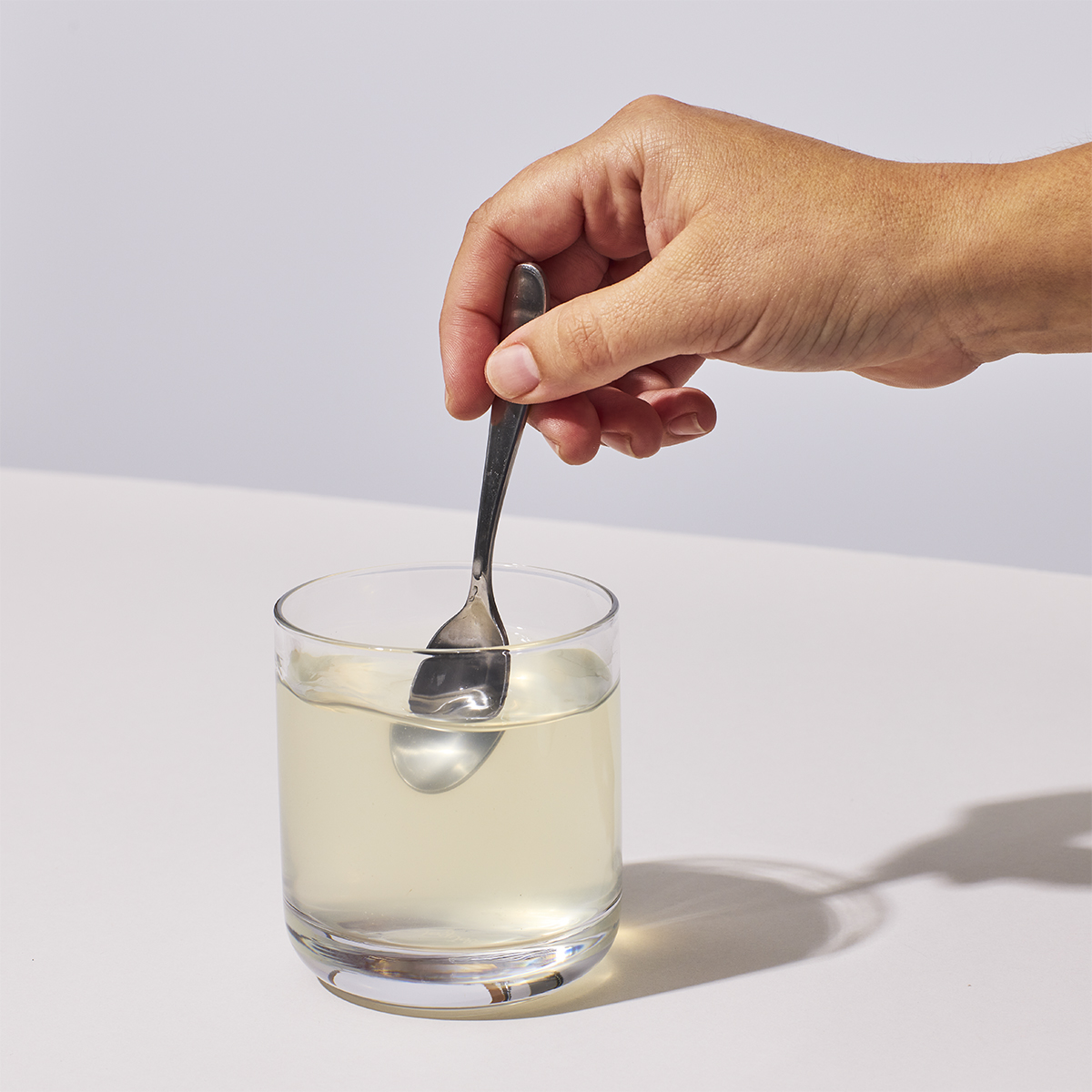 image of person stirring powder and water in a glass