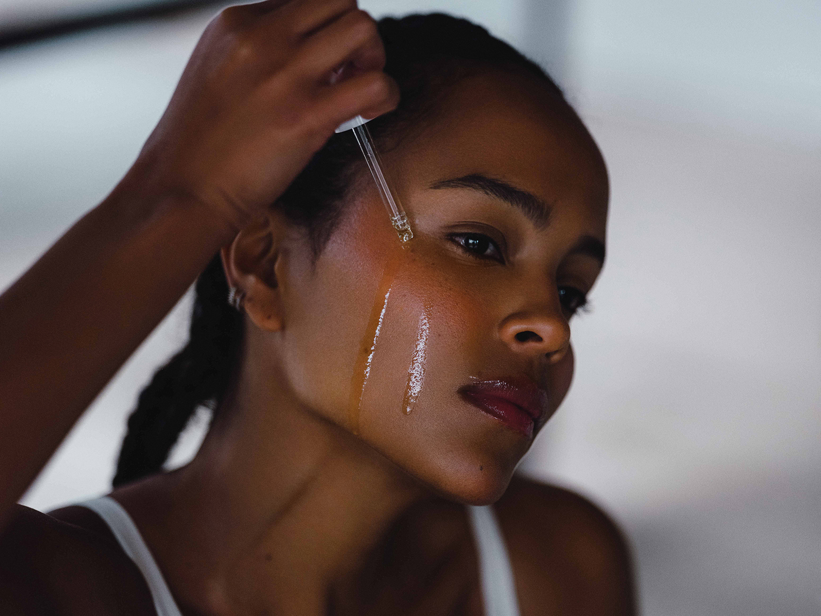 Woman applying serum to her face