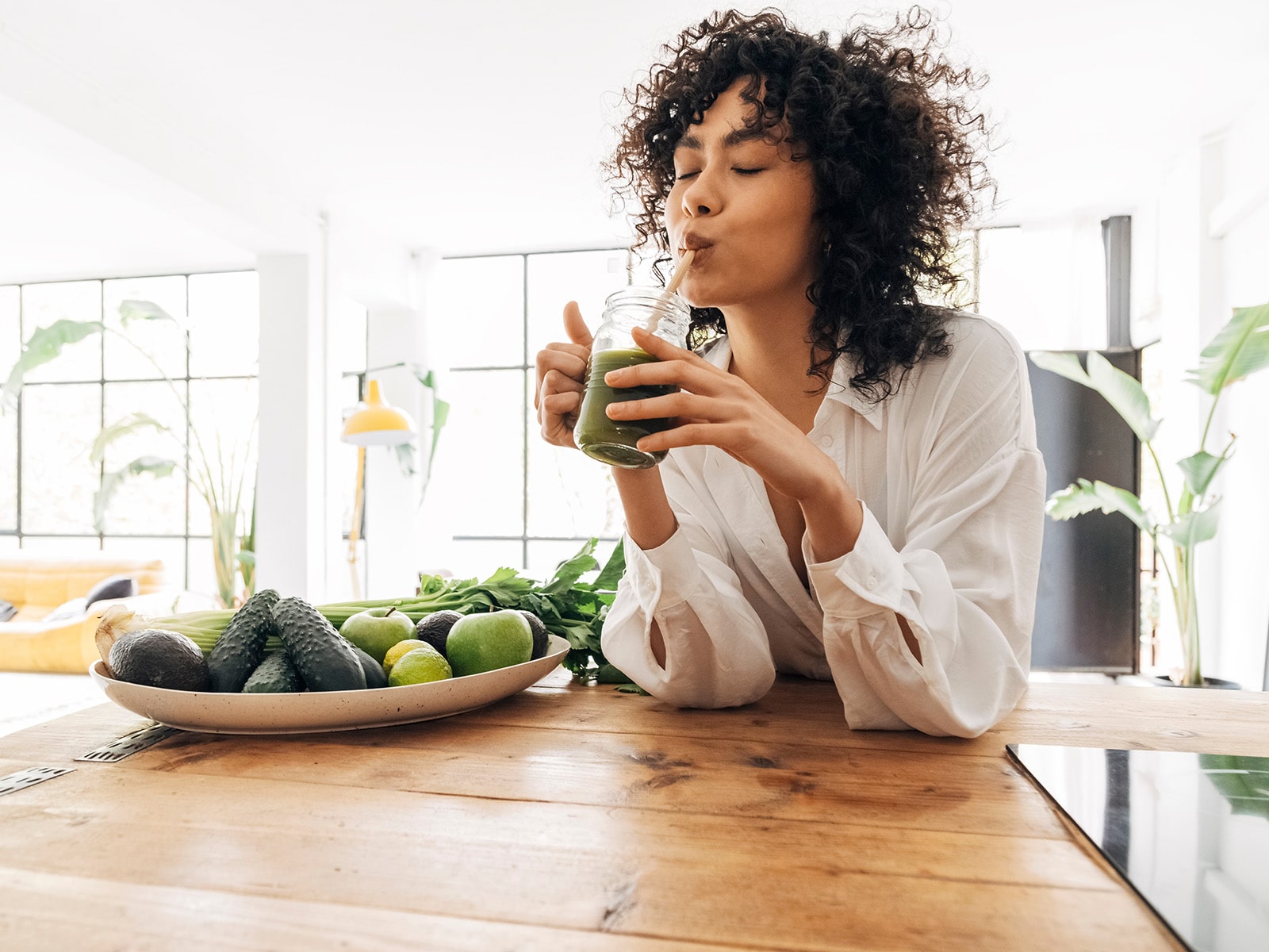 image of woman drinking green smoothie
