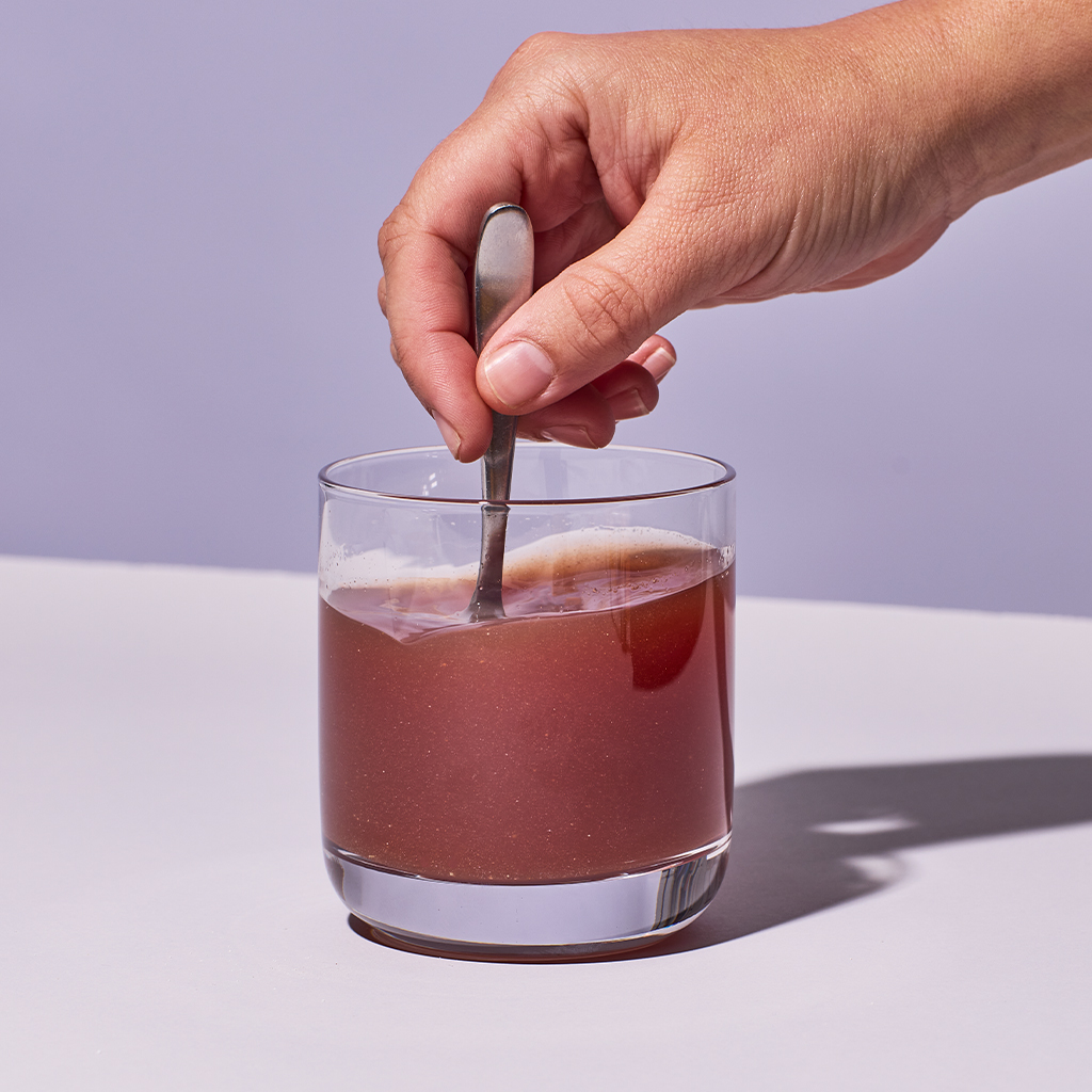 image of someone stiring up Isotonix Turn Up powder with water