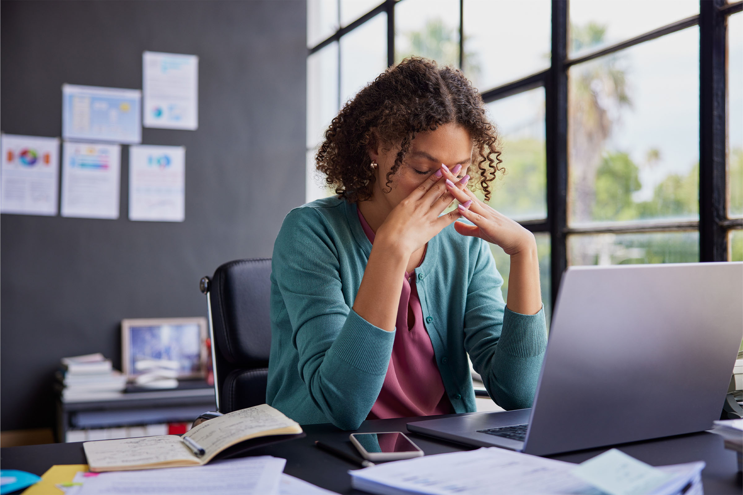 image of woman sitting at desk looking stressed
