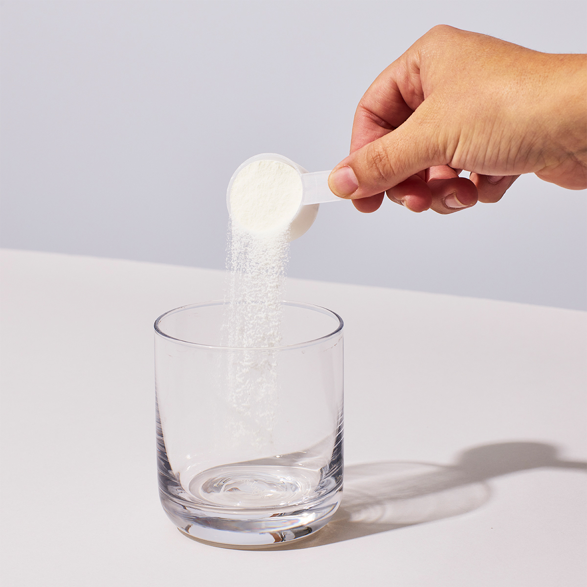 image of person adding scoop of NutriClean Fiber Powder to glass