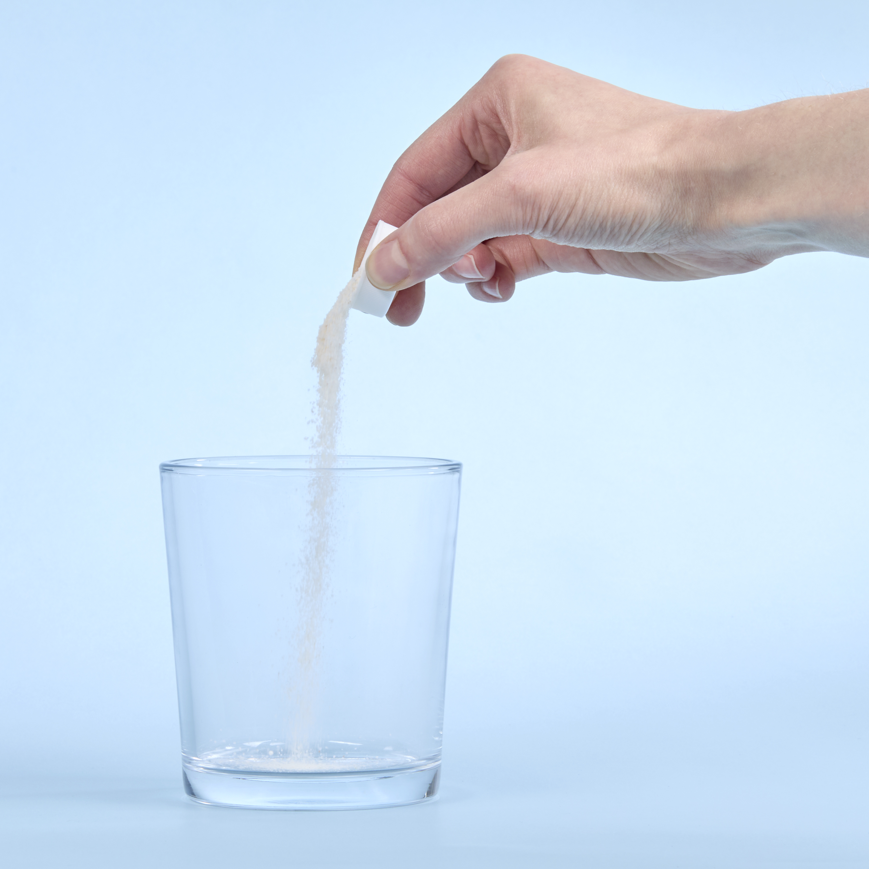 image of person pouring Isotonix Activated B Complex into a glass