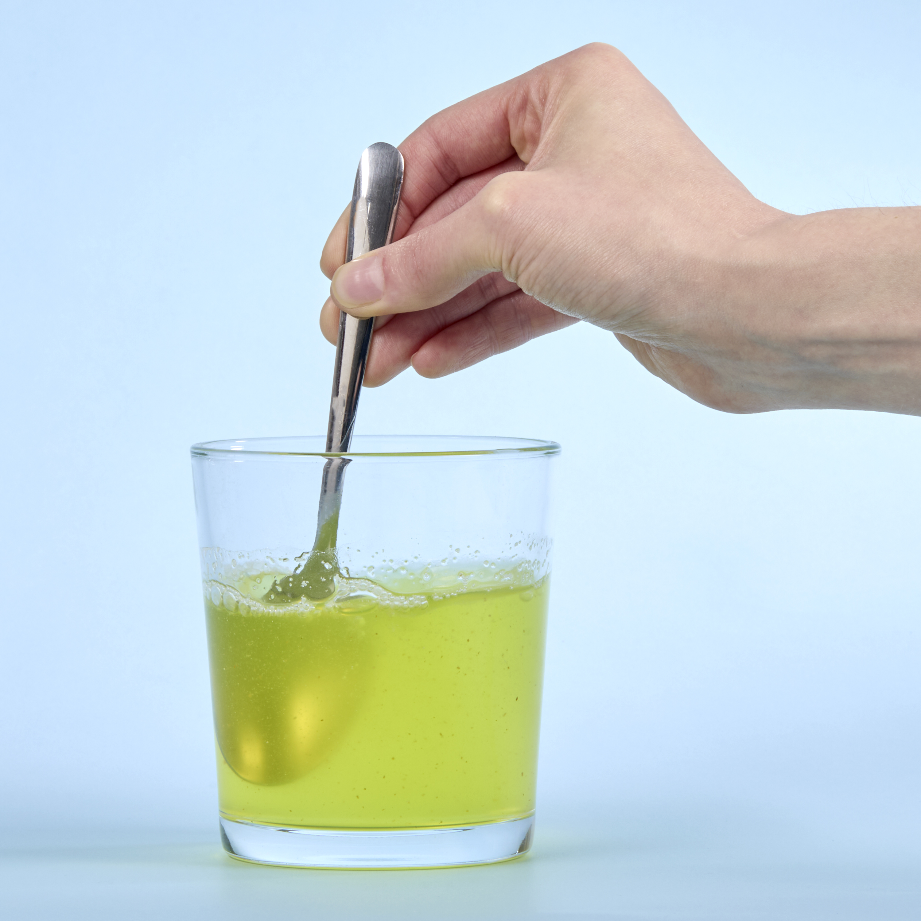 image of a person mixing Isotonix B Complex with a spoon.