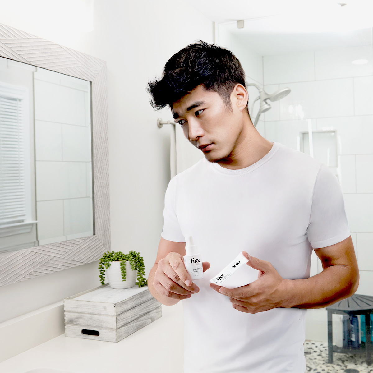 image of man holding Fixx Revival Serum and Fixx Re-Gro