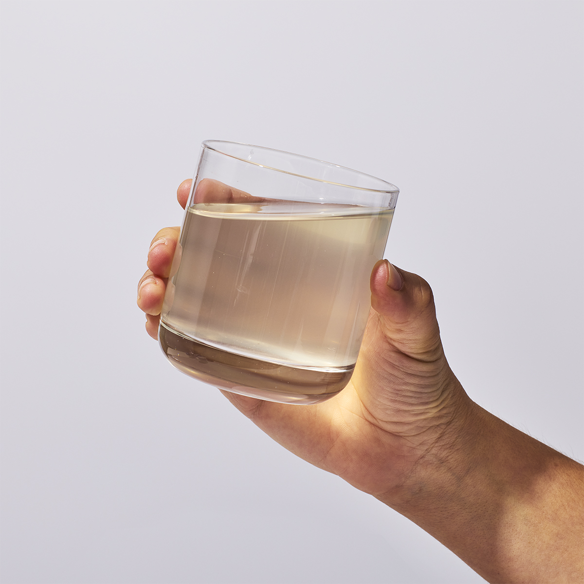 image of person raising glass of mixed product to drink