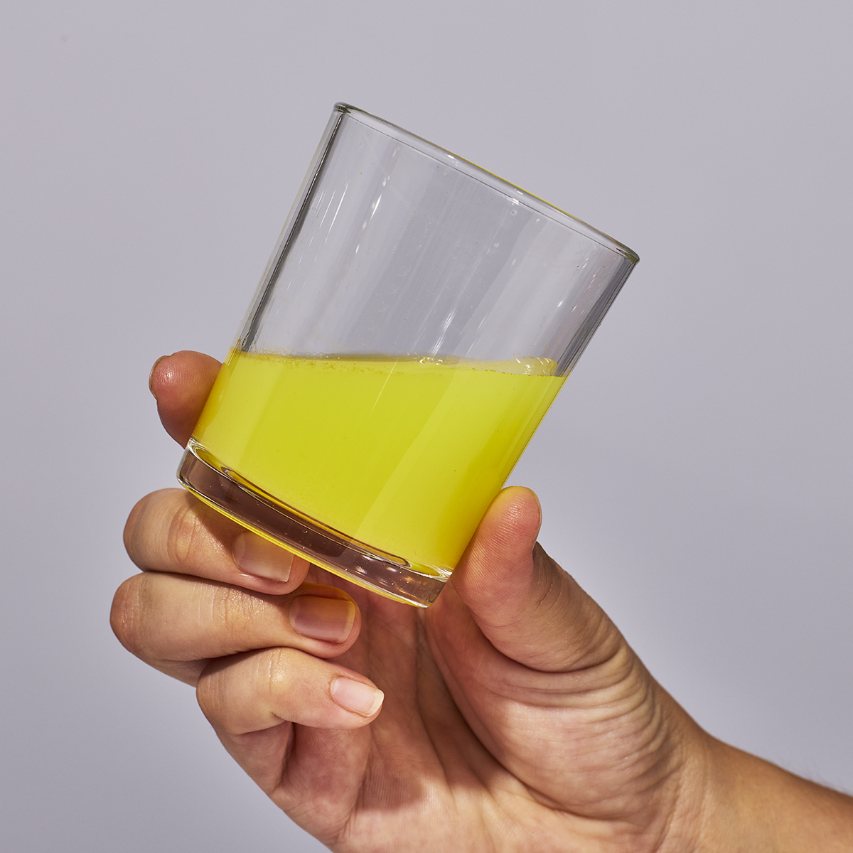image of person holding a glass containing one serving of Isotonix Coenzyme Q10.