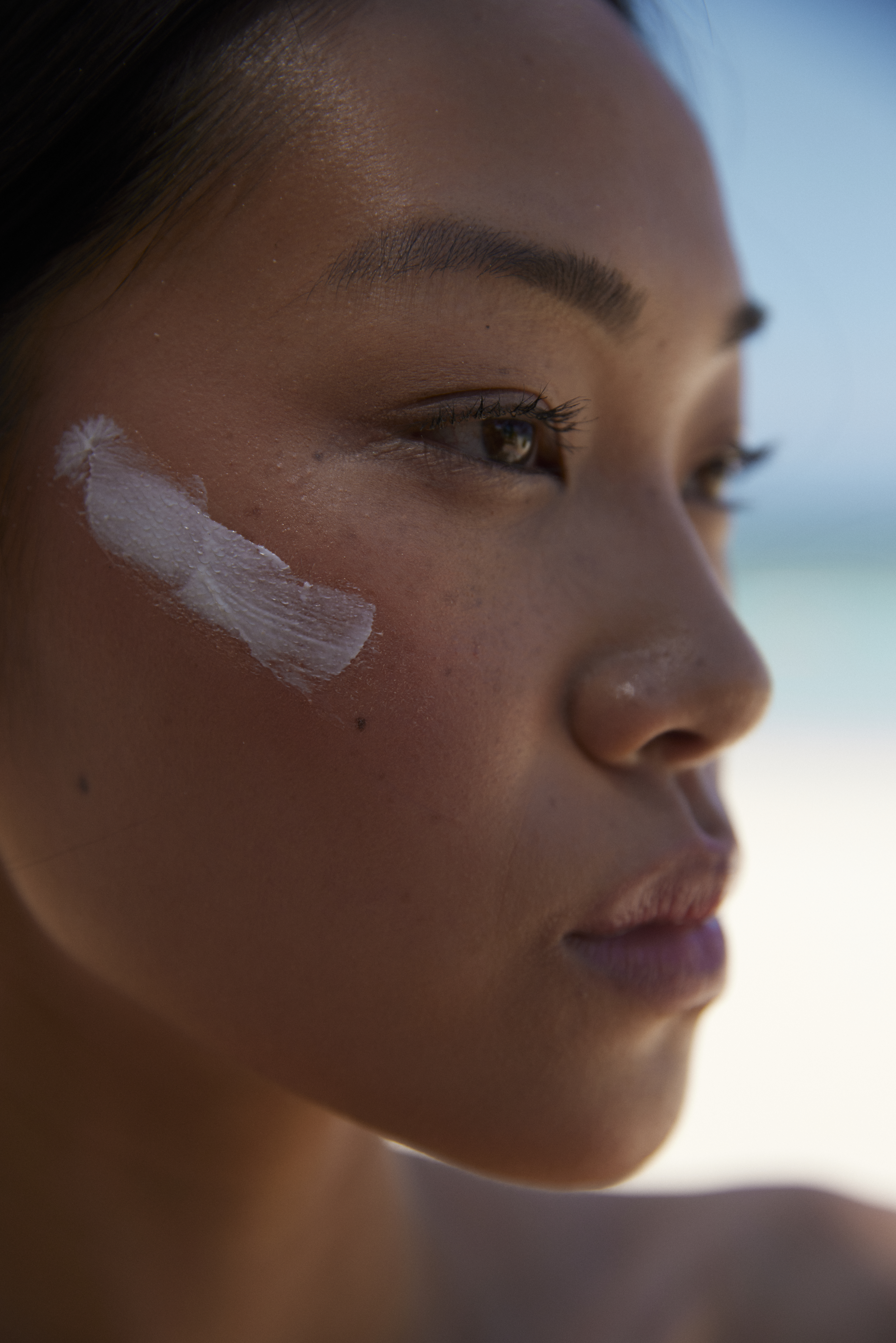 Woman with a streak of sunscreen on her cheek