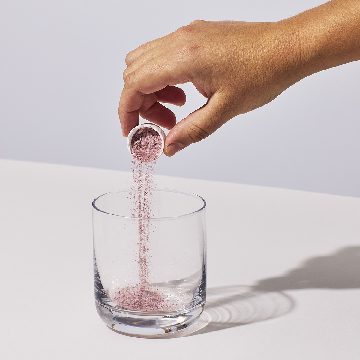 image of someone pouring one serving of Isotonix Acai powder into a glass