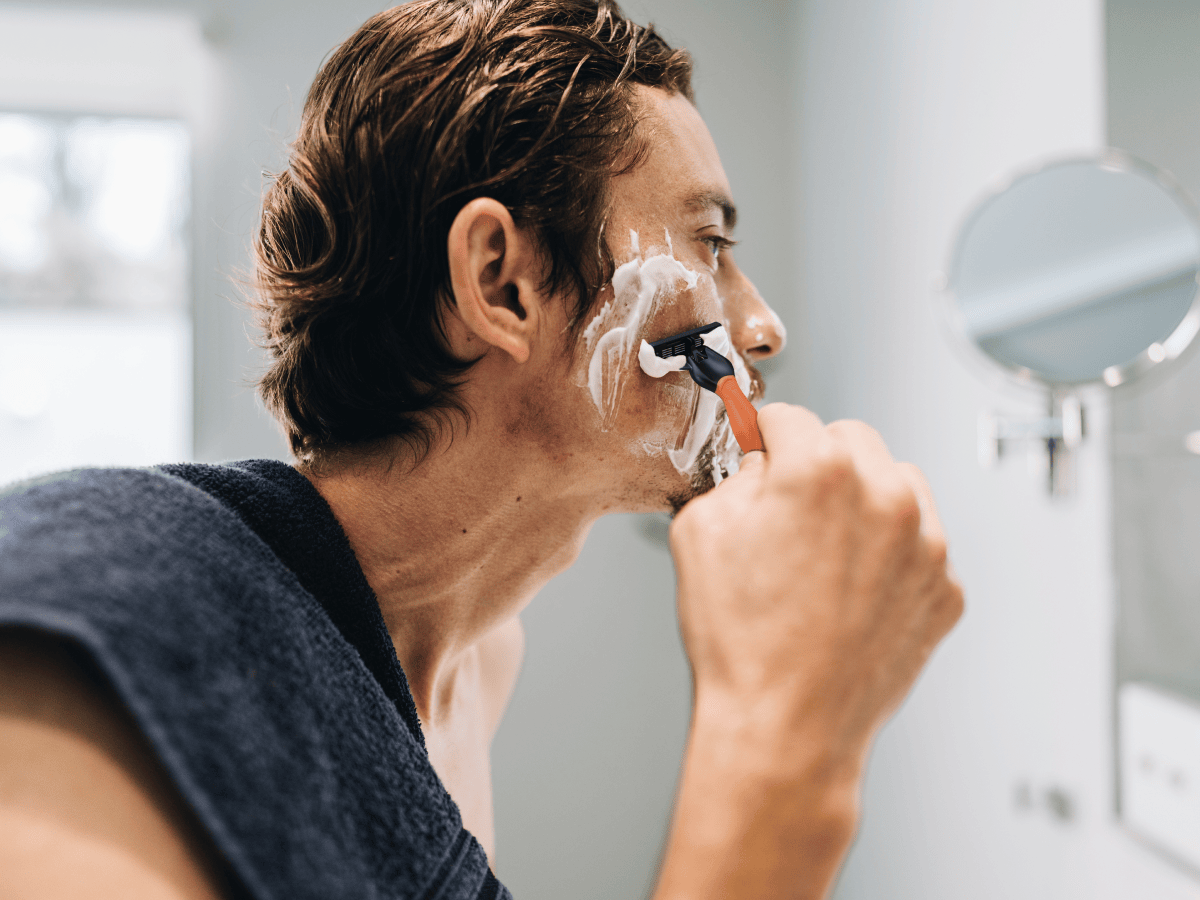 image of a man shaving his face