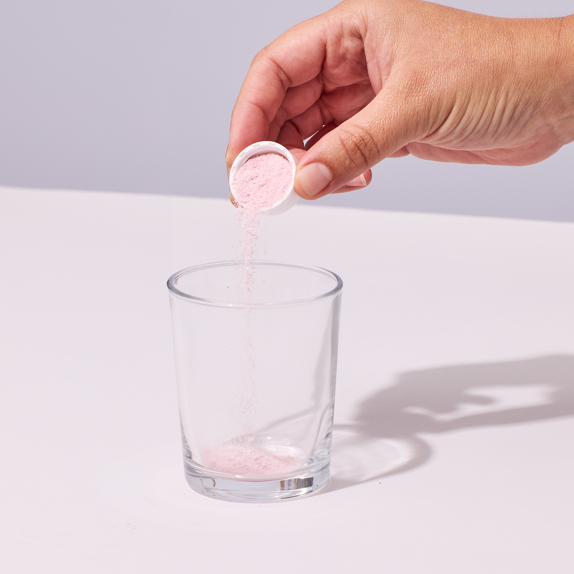 image of capful of Isotonix powder being poured into glass