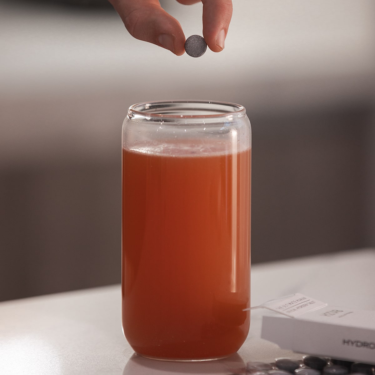 image of H2TAB being dropped into glass of Daily Essentials mix