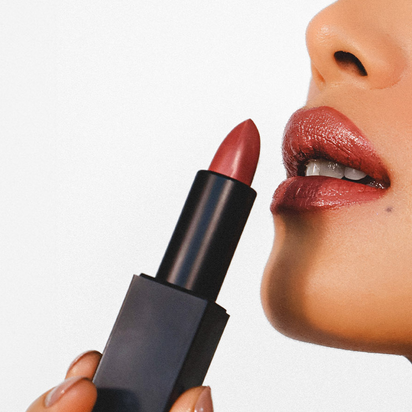a women is holding a lipstick next to the lip