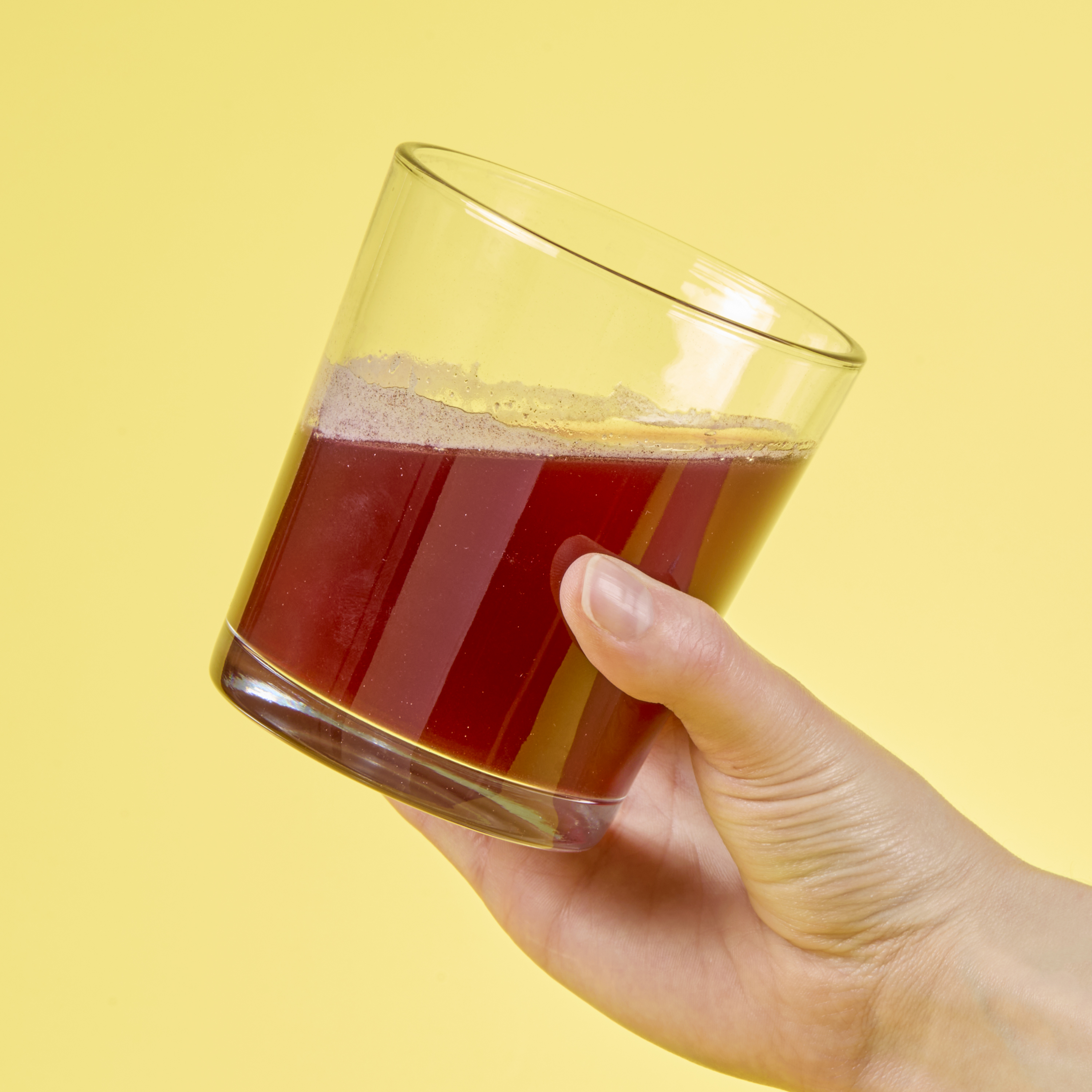 image of person raising glass to drink mixed product