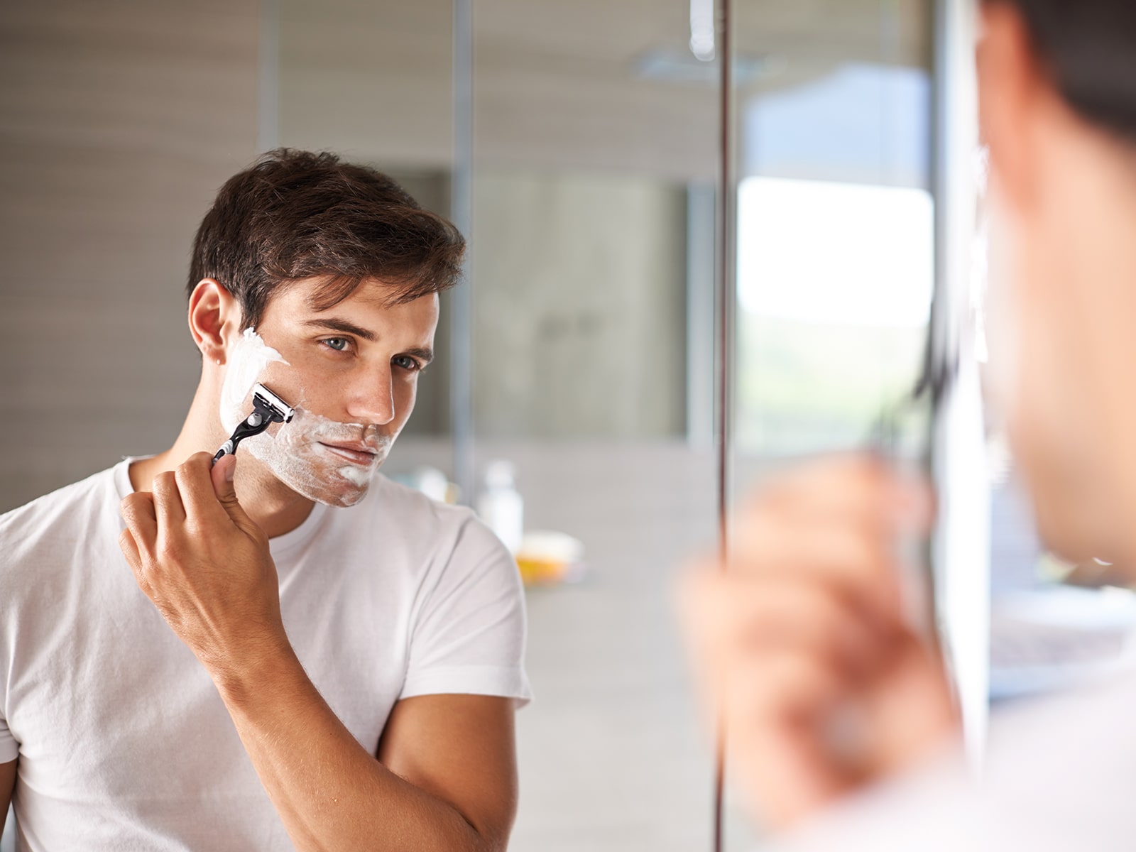 image of a man shaving his face
