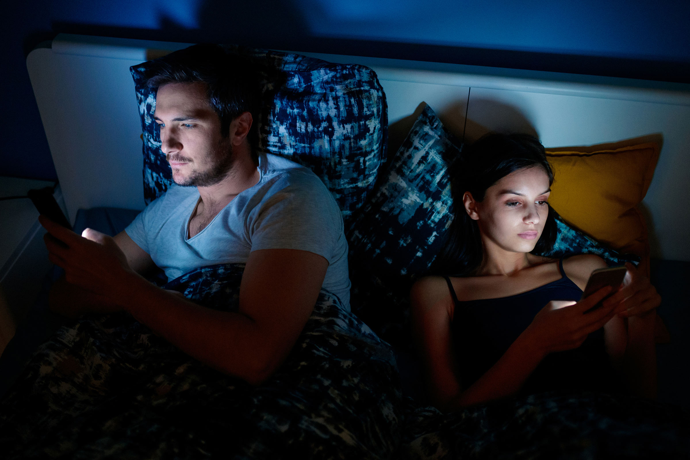 image of people looking at phone screens at night