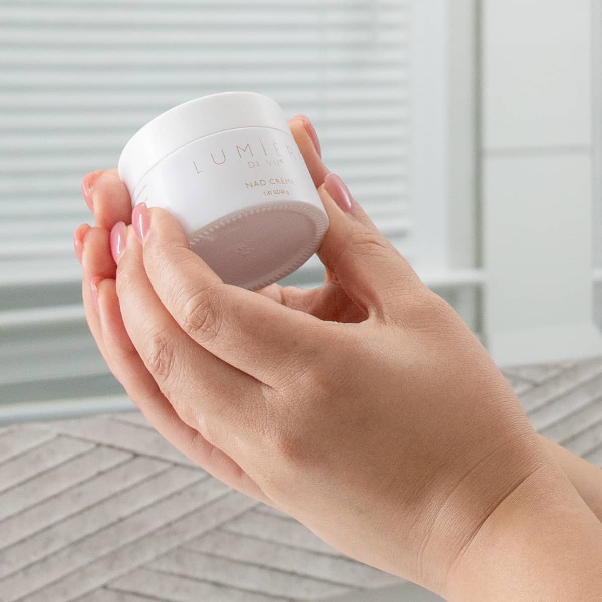 image of hands holding jar of cream