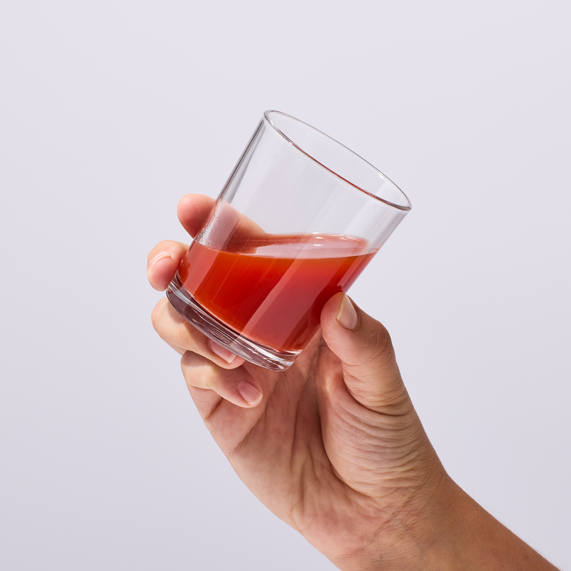 image of person raising glass to drink mixed product