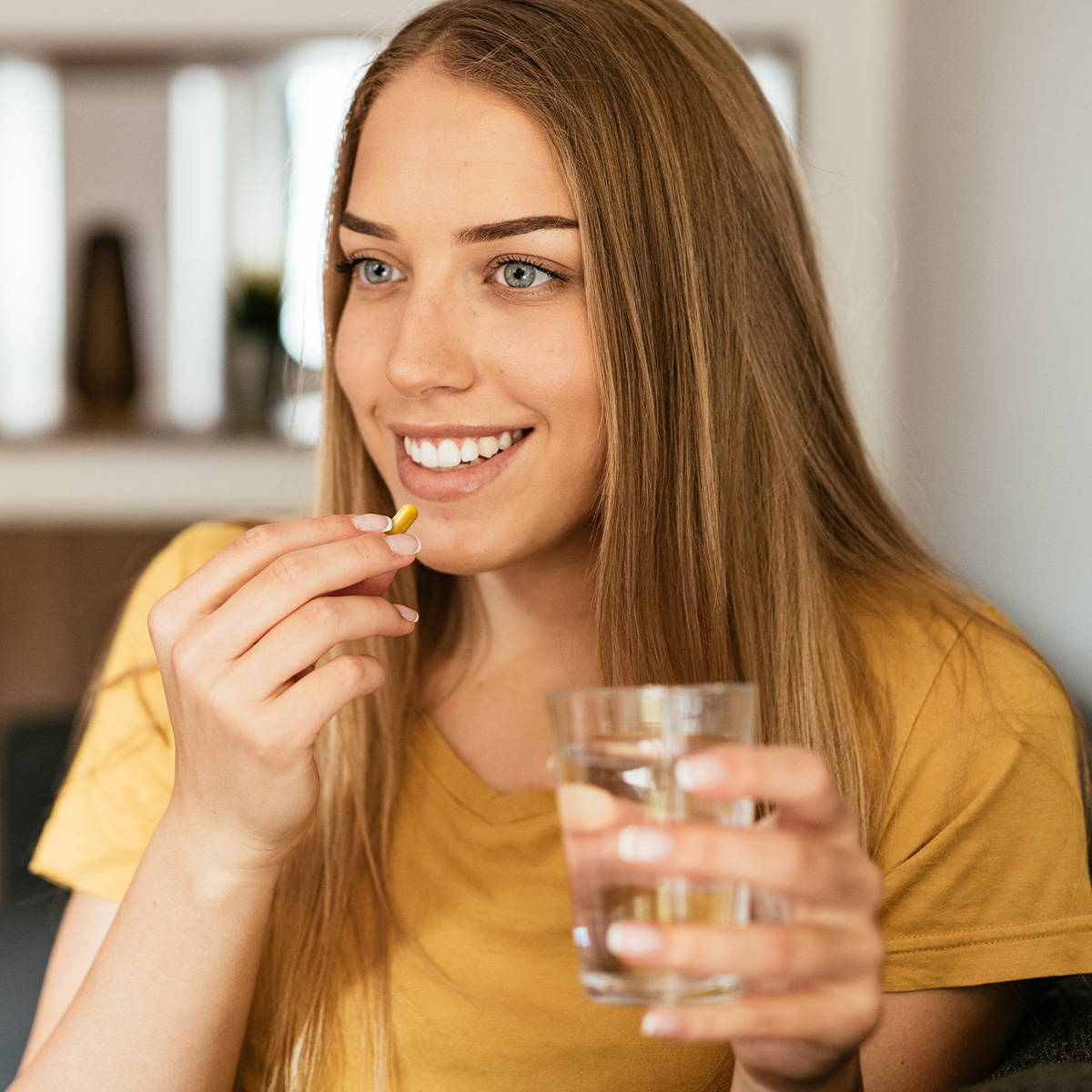 woman taking Curcumin Extreme with a glass of water.