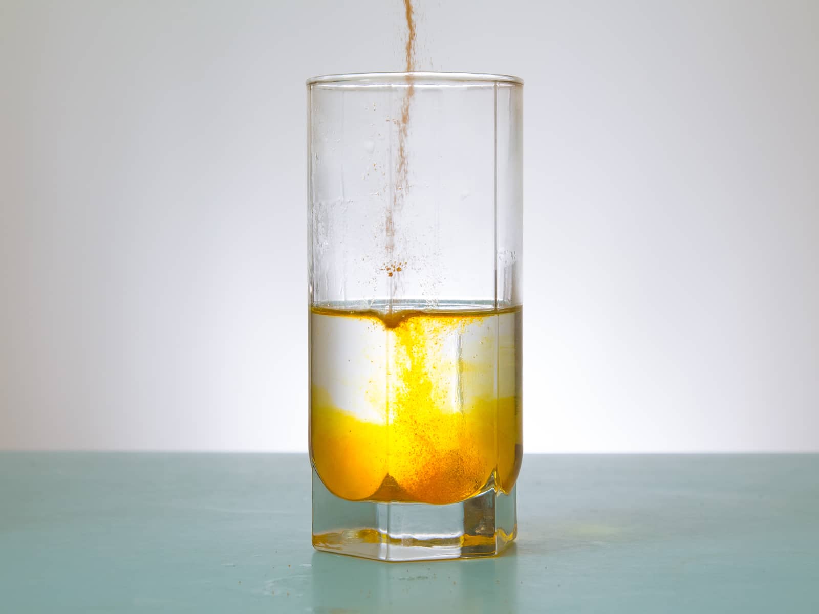 image of glass of water with powder being added