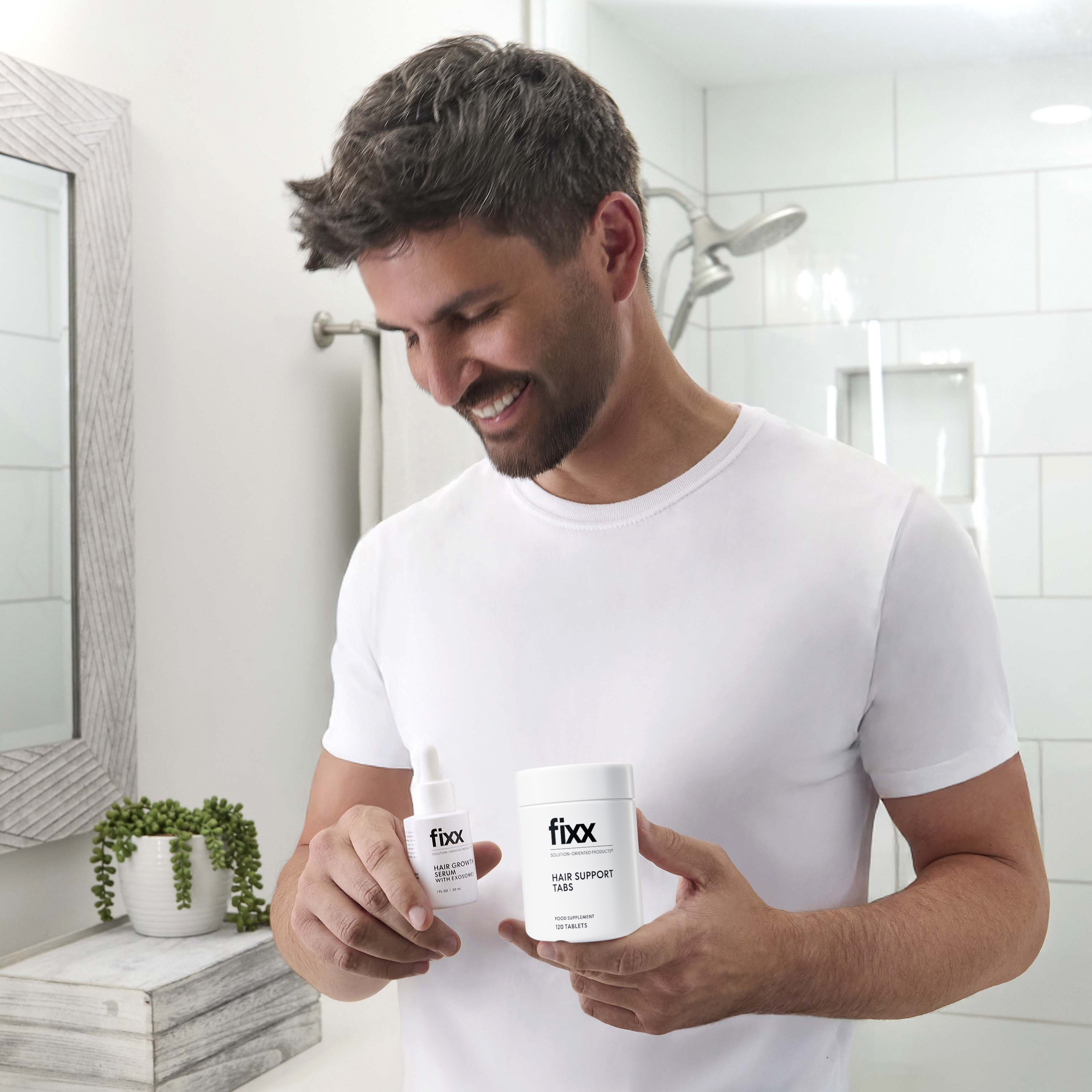 image of man holding Fixx Hair Growth Serum and Fixx Hair Support Tabs