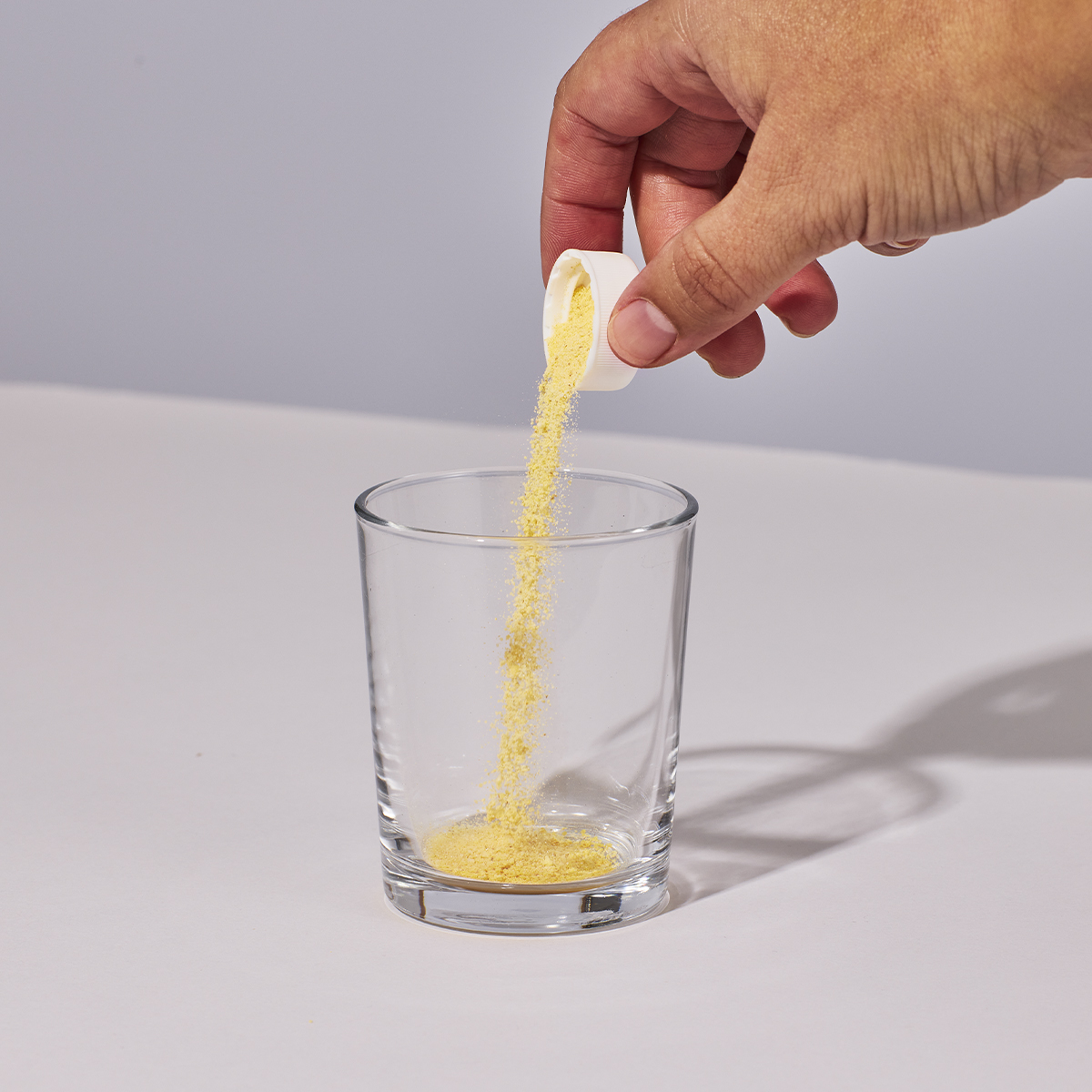 image of person pouring one capful of Isotonix Coenzyme Q10 into a glass