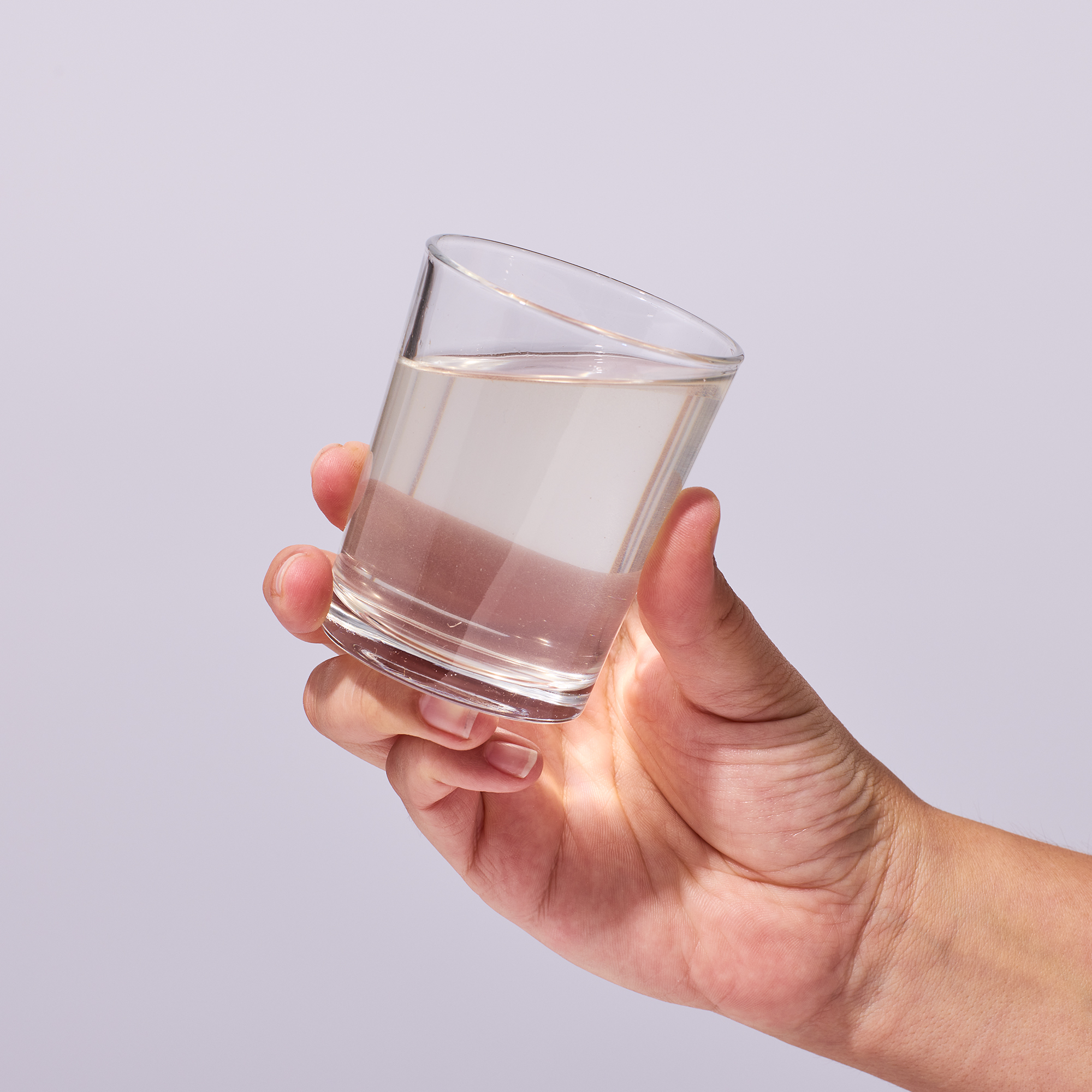 image of person raising glass to drink mixed product